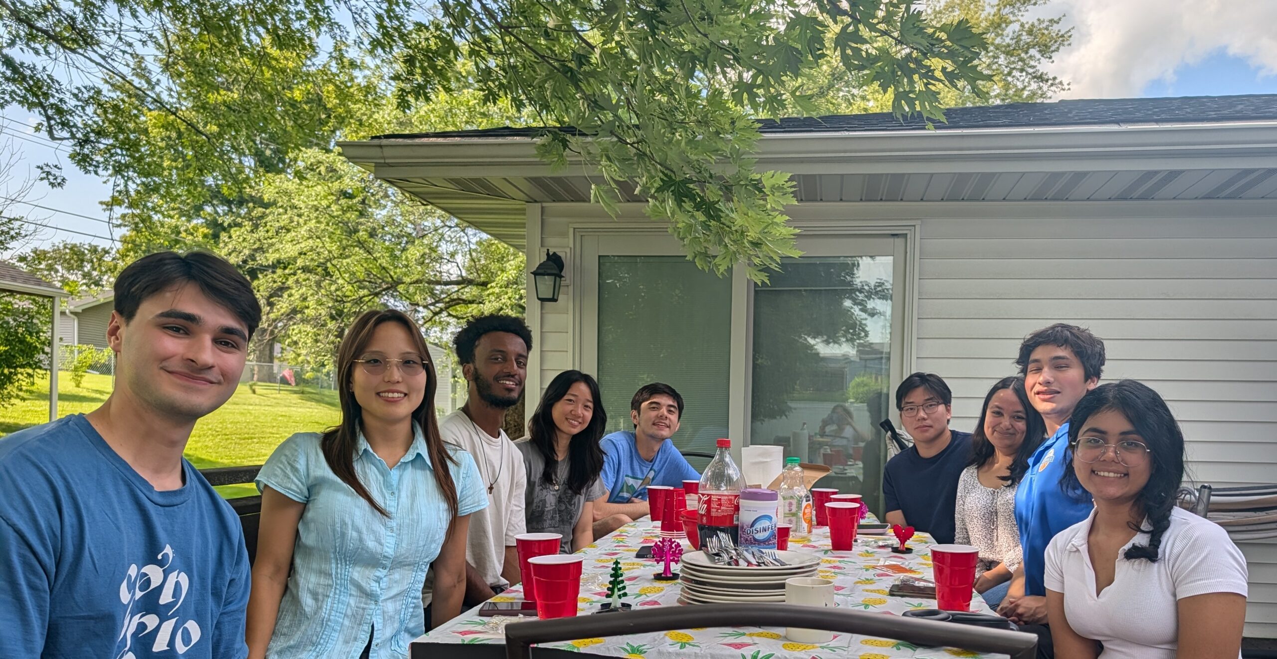 Nine students at a table outdoors