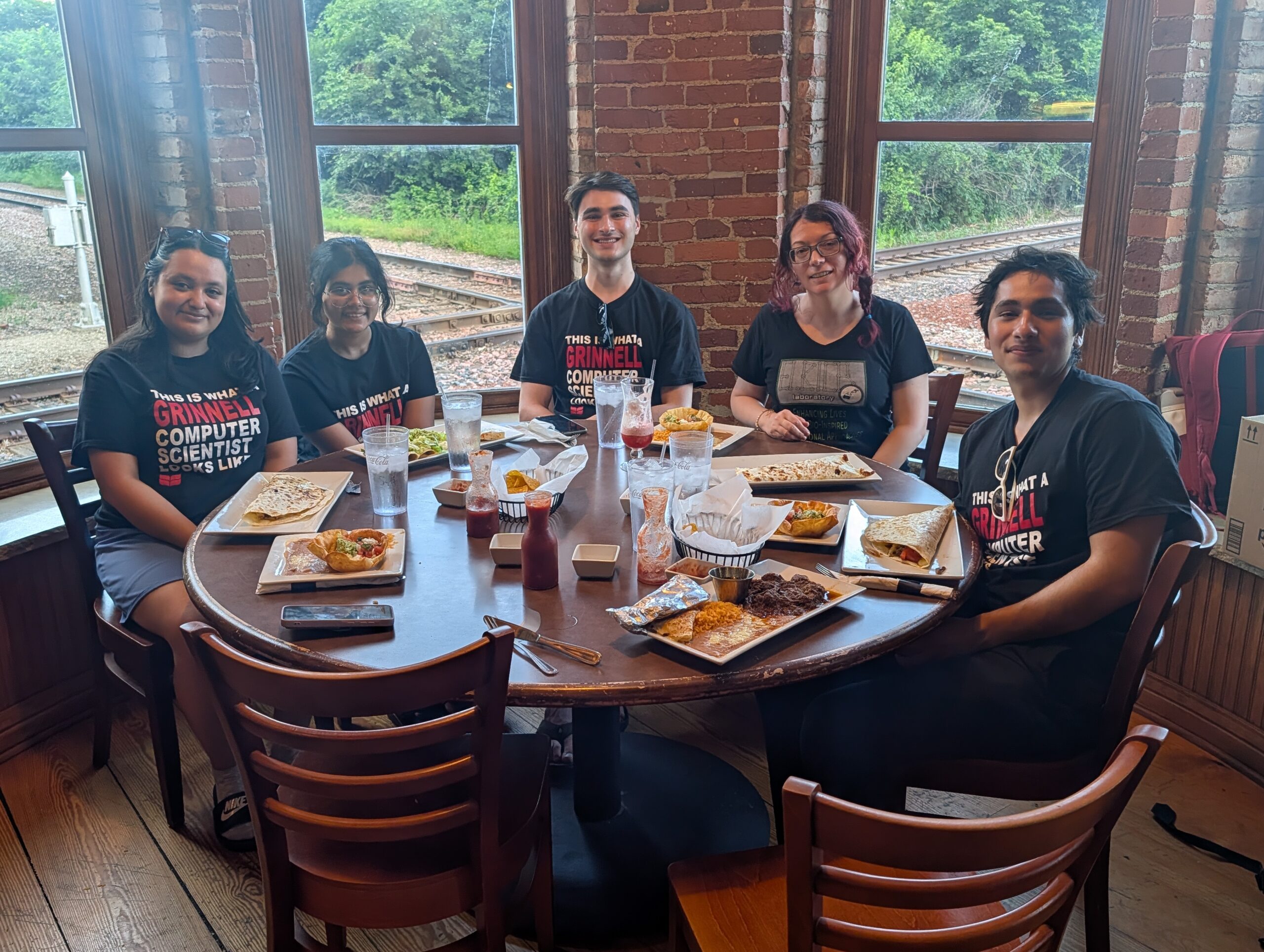 Four students and Professor Eliott having dinner